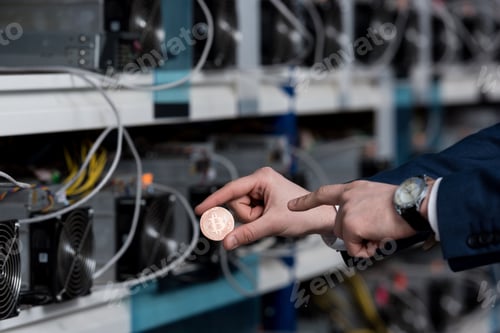 Preview: cropped shot of businessman pointing at bitcoin at cryptocurrency mining farm