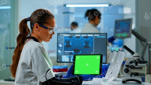 Preview: Medical research scientist working on tablet with green screen