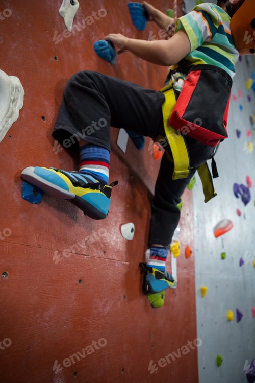 Preview: Boy practicing rock climbing in fitness studio