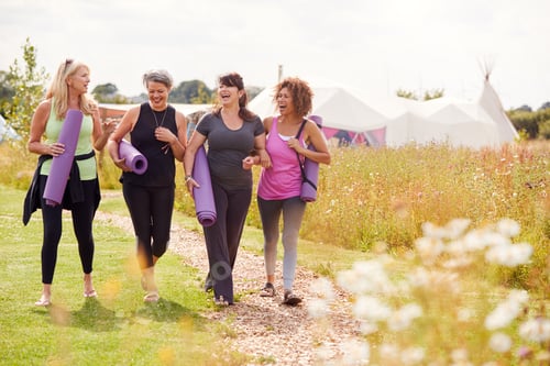 Vista previa: Group Of Mature Female Friends On Outdoor Yoga Retreat Walking Along Path Through Campsite