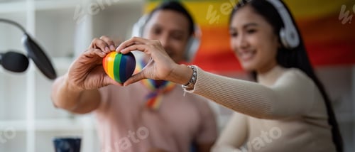 Preview: Young gay male and girl friend hands holding rainbow heart with smile face. LGBT, human rights and