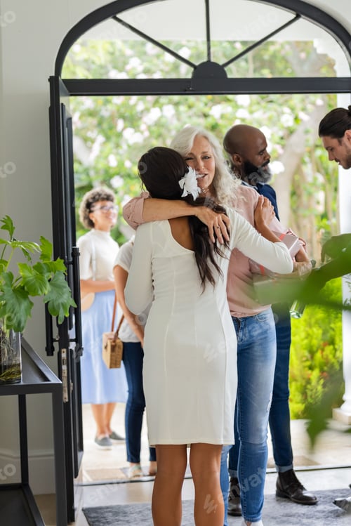 Preview: Guests warmly greeting each other at wedding entrance, sharing joyful embraces