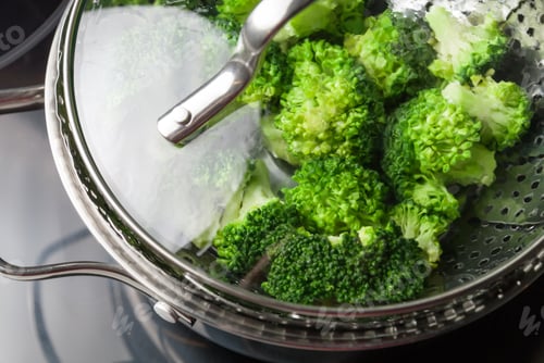 Preview: Freshly steamed green broccoli in skimmer pot