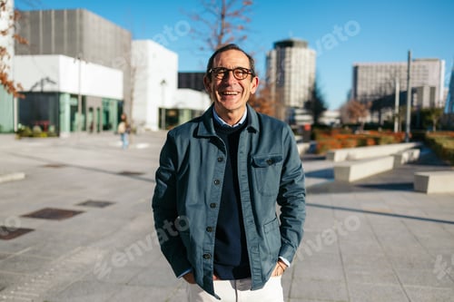 Preview: Mature man smiling confidently in an urban outdoor setting