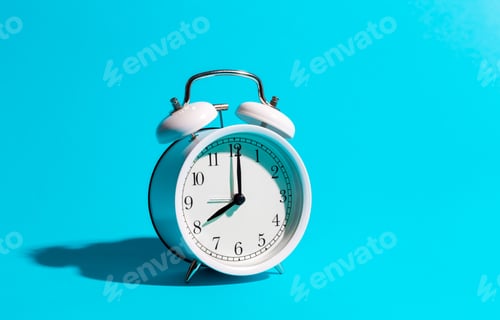 Preview: White alarm clock on a blue background isolated, close-up.