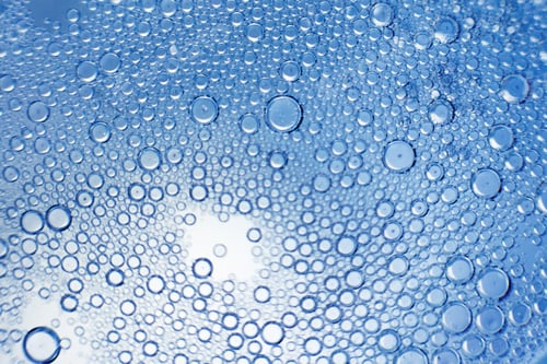 Preview: abstract light blue background with oil circles . bubbles of water close up .