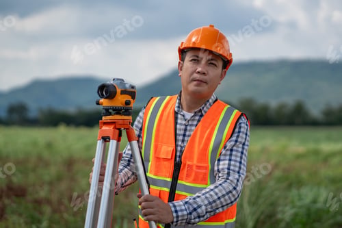 Preview: Survey team is working with a theodolite and road construction plans.