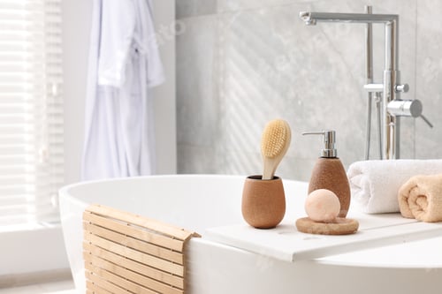 Preview: Different personal care products and accessories on bath tub in bathroom, space for text