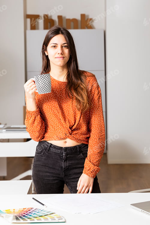 Preview: Woman working on laptop at office whit a cup of tea.