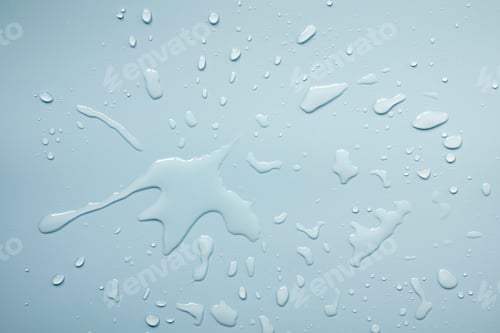 Preview: Spilled water on a gray surface, in the form of beautiful splashes. Abstract background. Top view.
