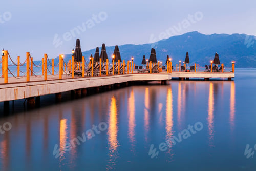Preview: Evening view of the pier with sun loungers and parasols.