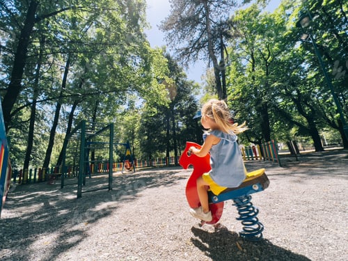 Preview: Little girl swinging on a swing-spring in the playground