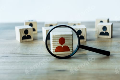Preview: selective focus of magnifying glass near cubes on wooden desk