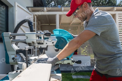 Preview: Adult Man Cutting Wood with a Saw Outside