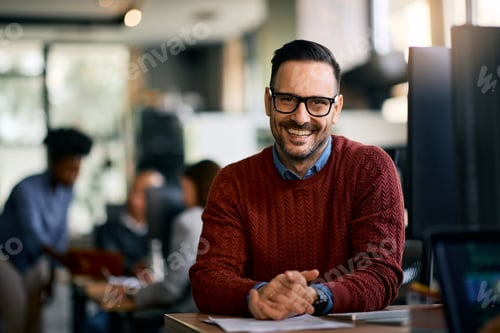 Preview: Happy entrepreneur working at IT office and looking at camera.