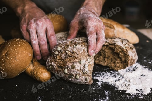Preview: Baker man holding a rustic organic loaf of bread in his hands