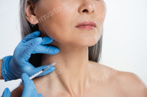 Preview: cropped view of naked woman and doctor in latex gloves holding syringe with beauty injection