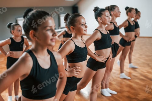 Preview: Group of female kids practicing athletic exercises together indoors