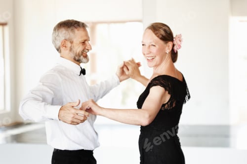 Preview: Still young at heart. Shot of a mature couple dancing together in formal attire.