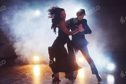 Preview: Skillful dancers performing in the dark room under the concert light and smoke