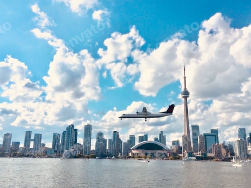 Preview: Regional jet coming in for a landing with Toronto cityscape in the background.