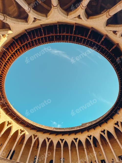 Preview: A large, circular building with a blue sky above it