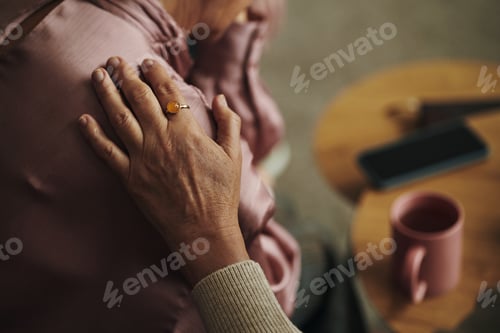 Preview: Hand of Senior Woman Comforting Elderly Friend Indoors