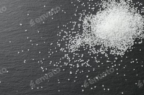 Preview: Heap of granulated sugar on black table, top view. Space for text