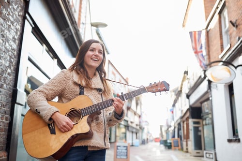 Preview: Female Musician Busking Playing Acoustic Guitar Outdoors In Street