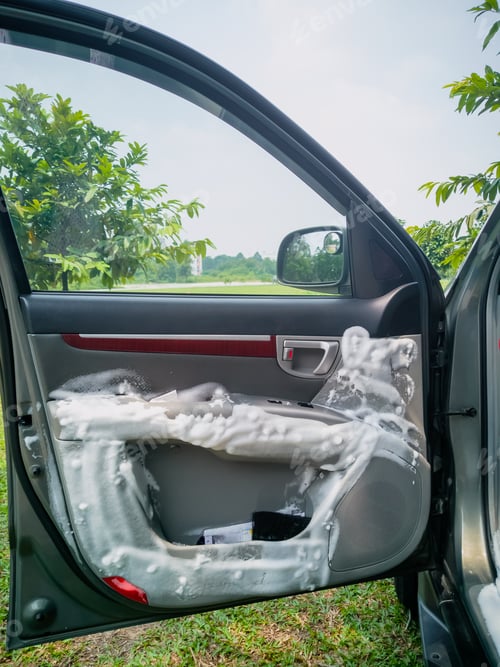 Preview: Dry cleaning the car interior with special foam. Car care concept. Car detailing. Cleaning.