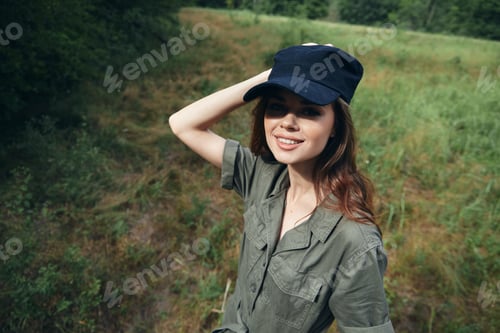 Preview: Woman in the forest Smile Look Forward green jumpsuit black cap summer