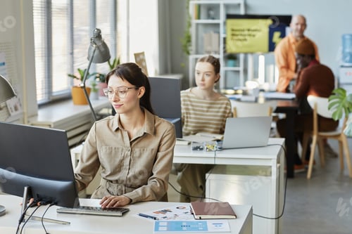 Preview: Young Businesswoman Using Computer At Workplace