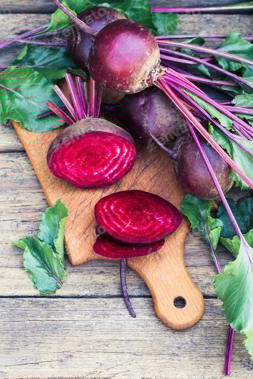 Preview: Fresh Whole and Sliced Beets on Wooden Board