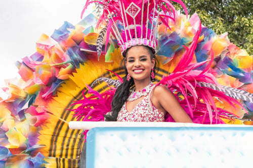Preview: woman in a sparkling pink costume on a parade float at a festival
