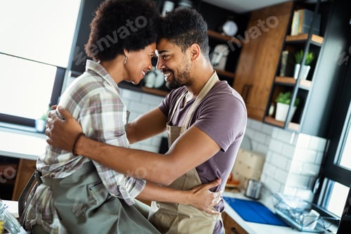 Preview: Beautiful couple are hugging and smiling while spending time in kitchen