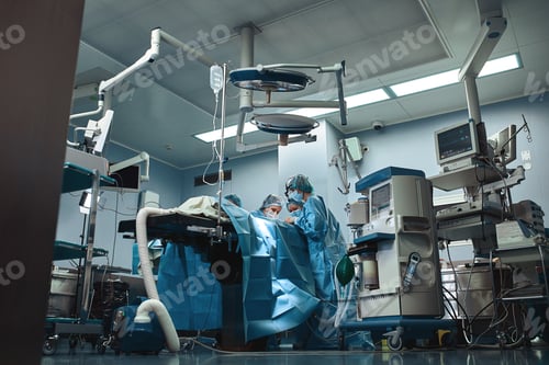 Preview: Surgical team operating on patient in theater in hospital