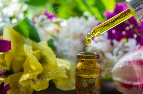 Preview: essential oil of flowers drips into a jar. selective focus.