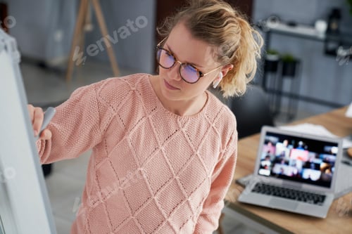 Preview: Female teacher writing on the blackboard while teaching at home