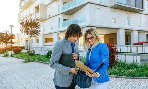 Preview: Businesspeople checking documents in the street