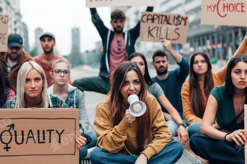 Preview: group of students sitting on the street with signs and megaphone screaming slogans