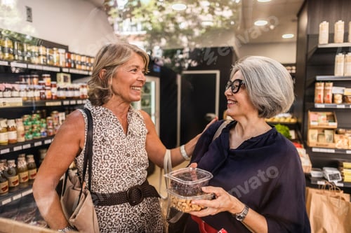 Preview: Senior women friends smiling while shopping for groceries