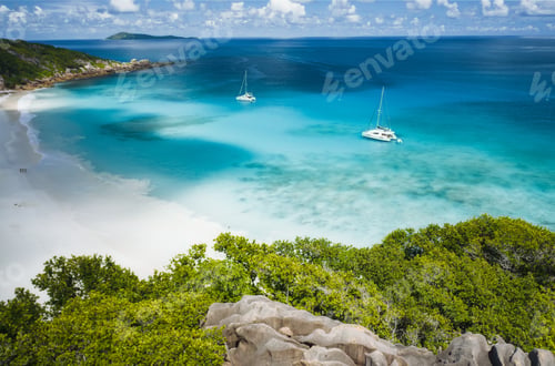 Preview: Aerial of Grand Anse beach at La Digue island in Seychelles. White sandy beach with blue ocean