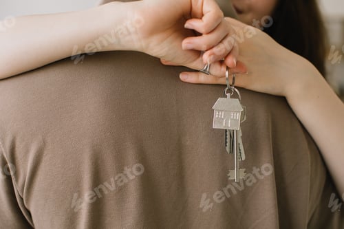 Preview: Crop close up of excited young Caucasian couple show keys to new shared home or dwelling.