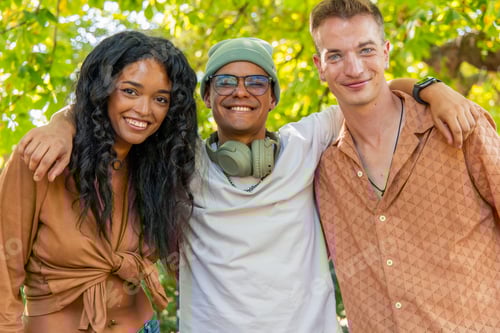 Preview: Group of young multicultural friends embracing and smiling in a park