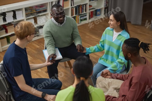 Preview: People in support group circle holding hands