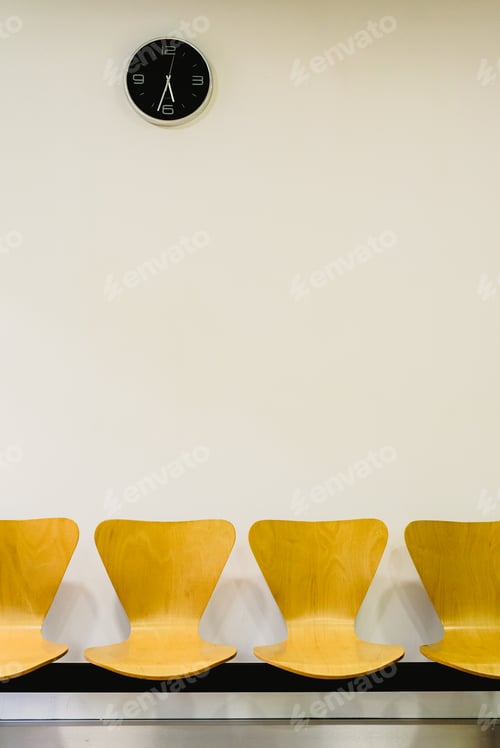 Preview: Waiting room with empty wooden chairs and wall clock, waiting concept.