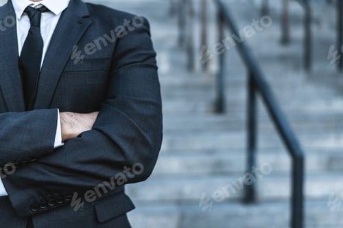 Preview: Close-up businessman crossing his hands posing against the background of the office stairs