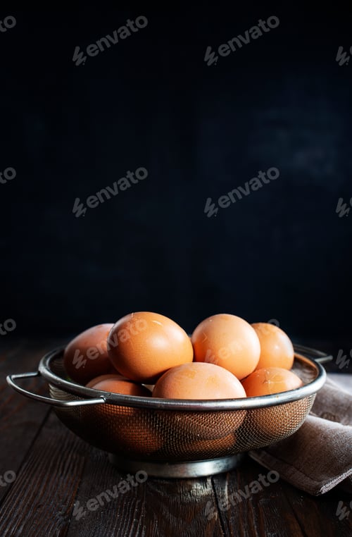 Preview: fresh eggs in metal basket on wooden table.