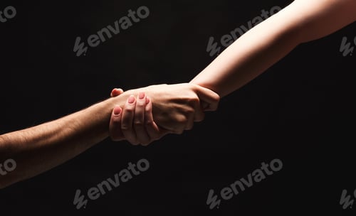 Preview: Hands of man and woman in love, isolated on black