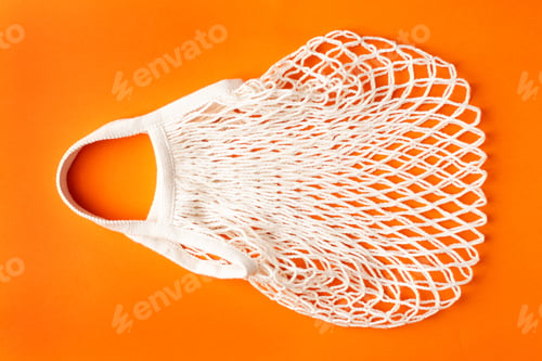 Preview: Cotton shopping eco friendly bag on orange background, zero waste and plastic free concept.